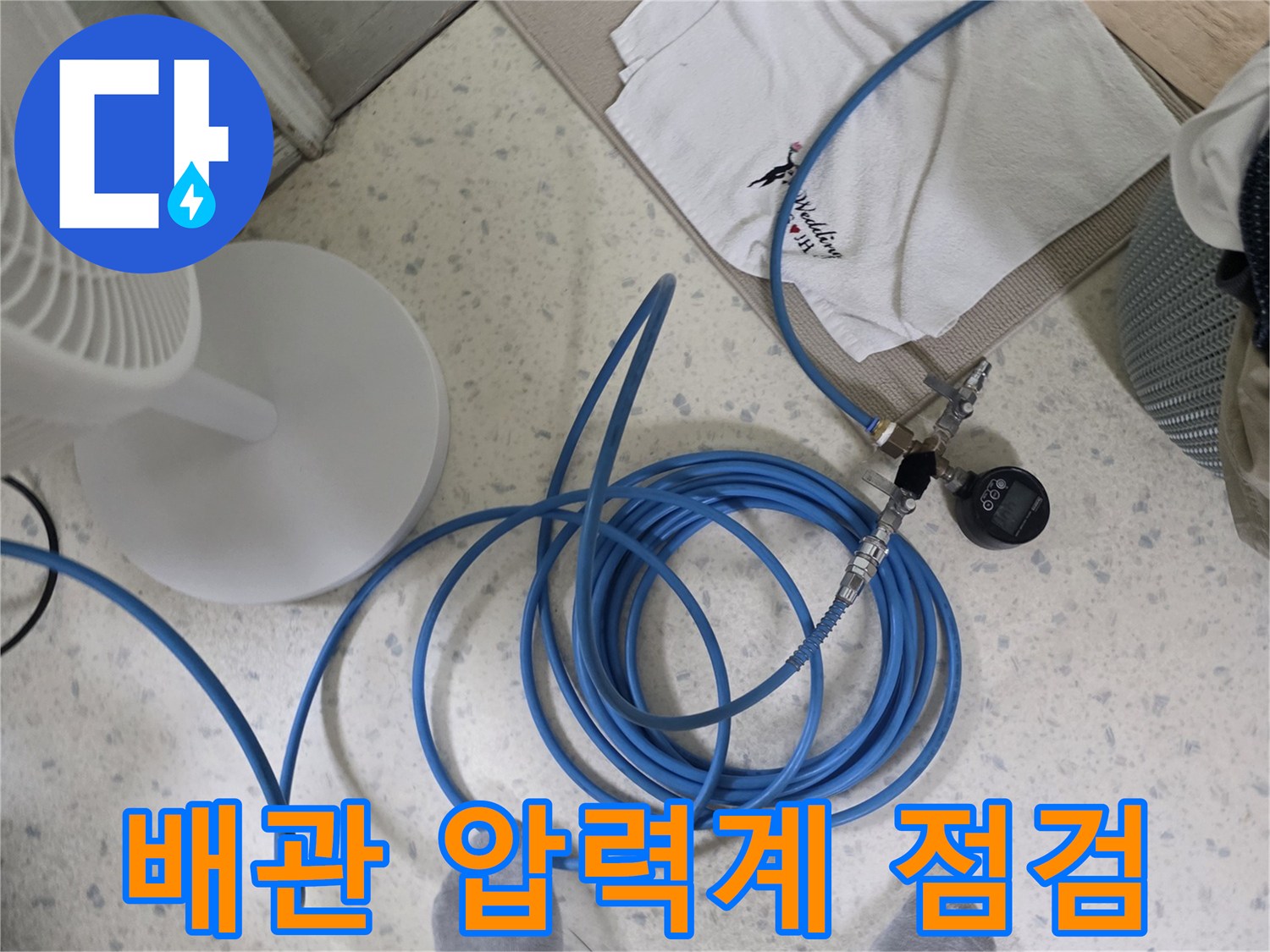 파란색 가스 탐지 호스와 압력 게이지를 배관에 연결하여 공압 테스트를 진행하는 모습