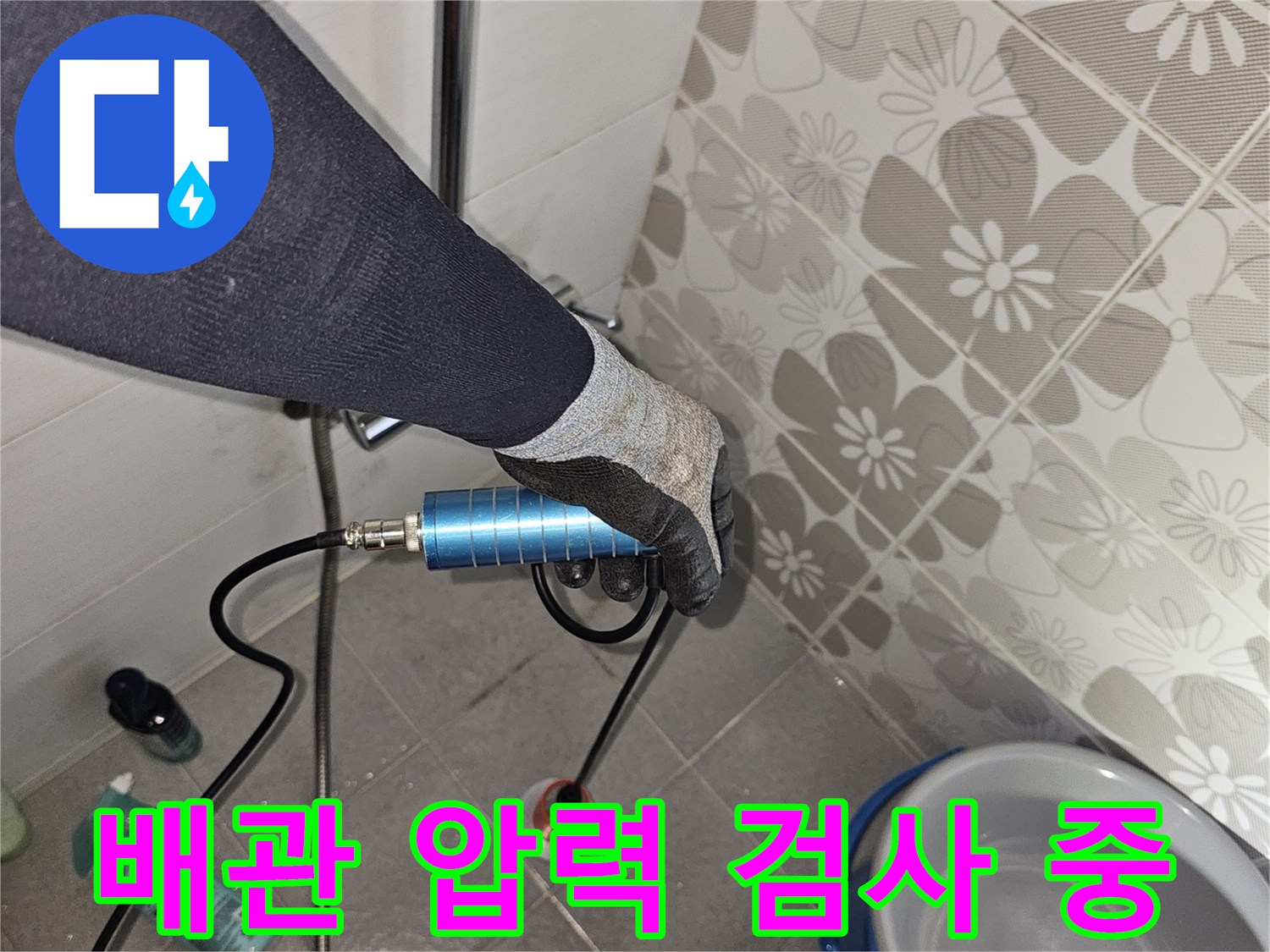 배수구 근처에 연결된 파란색 압력 측정 장치와 호스