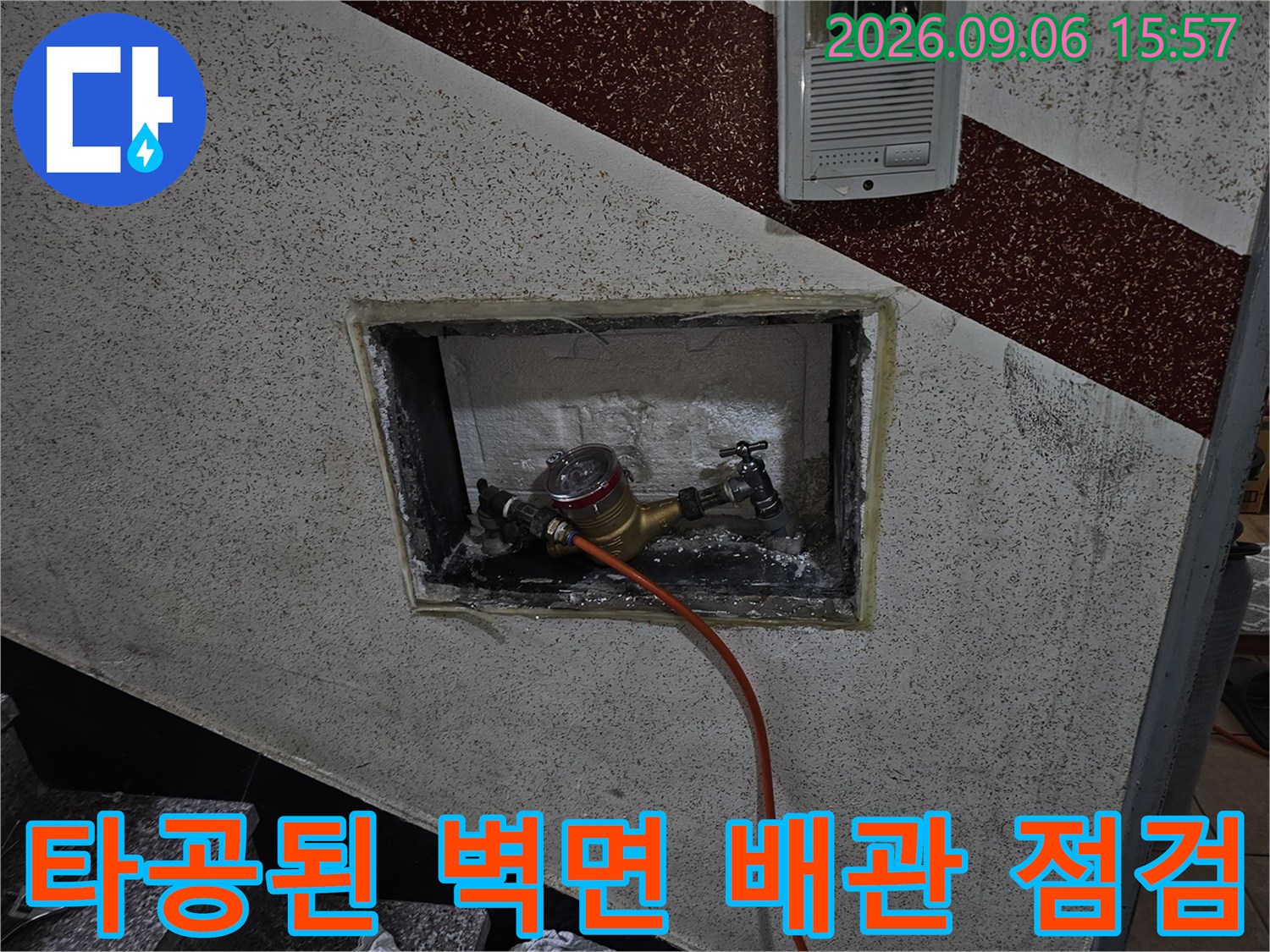 벽면 타공 부위 사이로 보이는 황동 재질의 수도 배관과 연결 장치