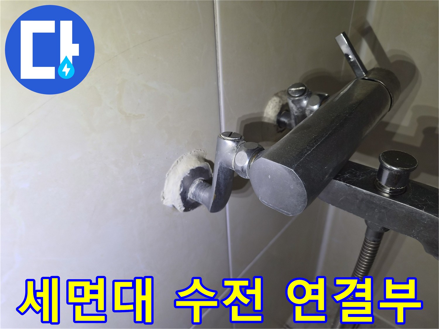 벽면에 고정된 은색 세면대 수전과 연결 배관의 모습
