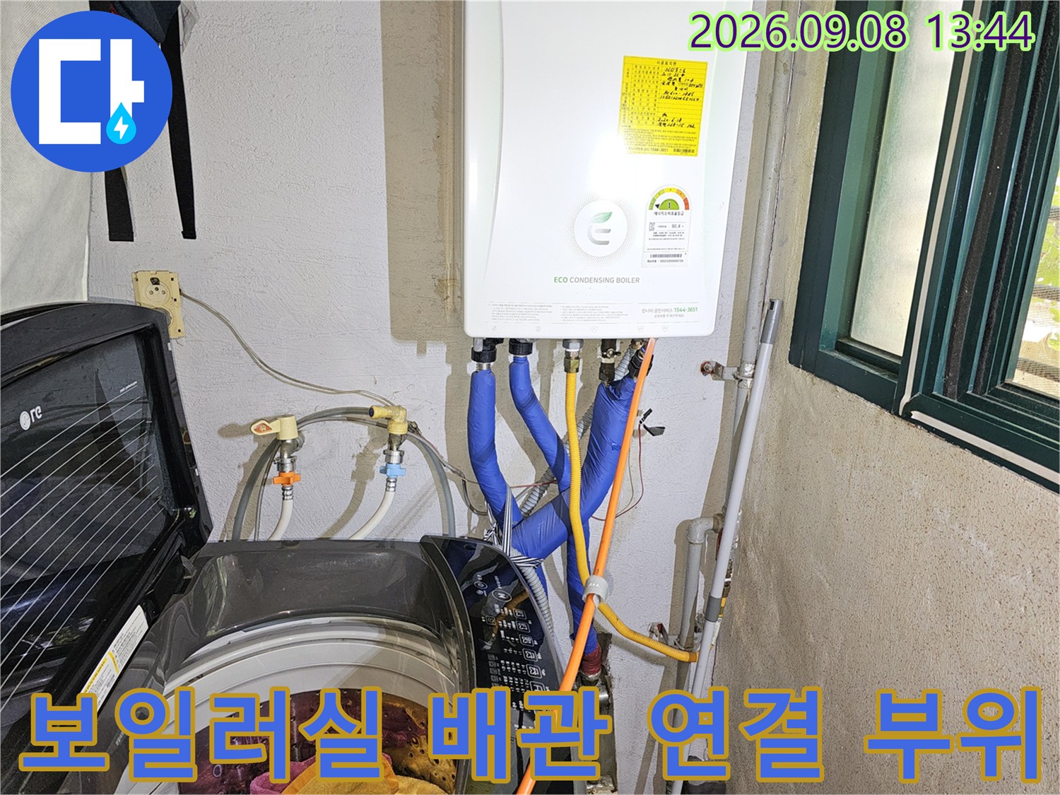 보일러 하단에 연결된 파란색 온수 배관과 주변 세탁기 시설