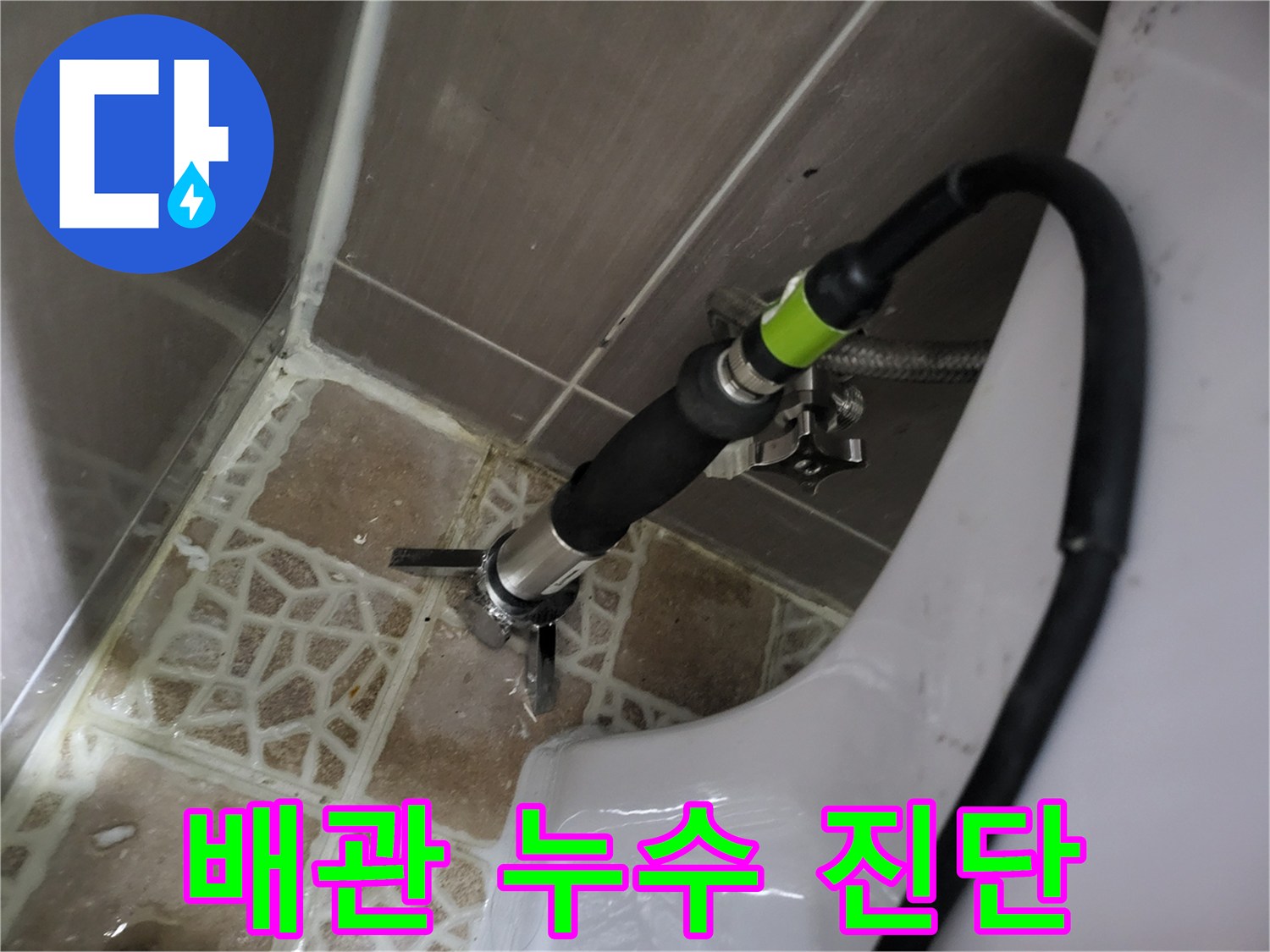 노출된 배관 연결 부위에 장비를 대고 누수 여부를 확인하고 있습니다.