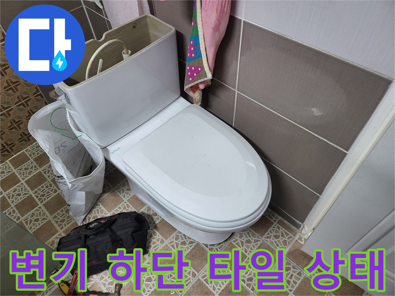 변기 탱크 측면과 바닥 타일이 보이는 사진
