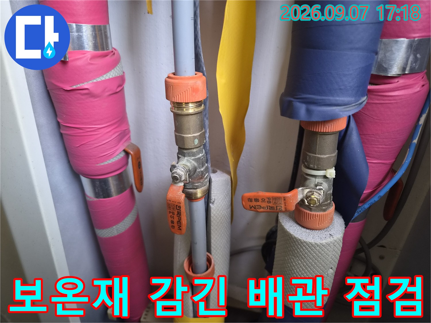 분홍색과 파란색 보온재가 씌워진-배관의 연결 부위를 상세히 촬영했습니다.