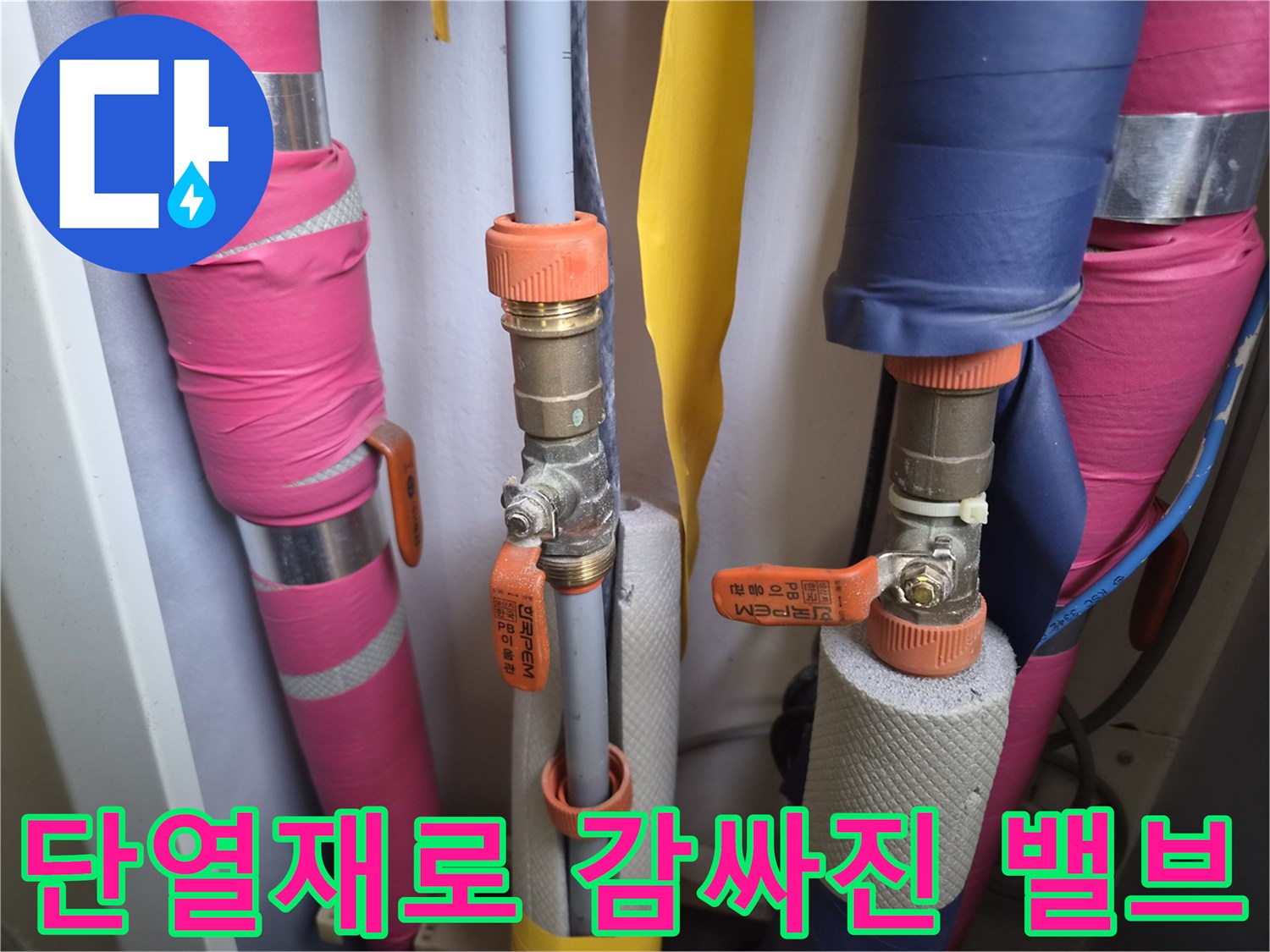 주황색 손잡이가 달린 금속 밸브와 배관 보온재