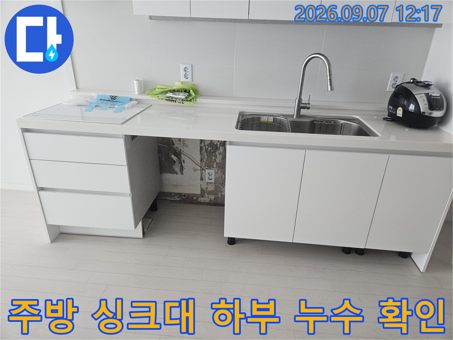싱크대 아래 정수기 호스 연결 부위의 훼손된 상태 사진