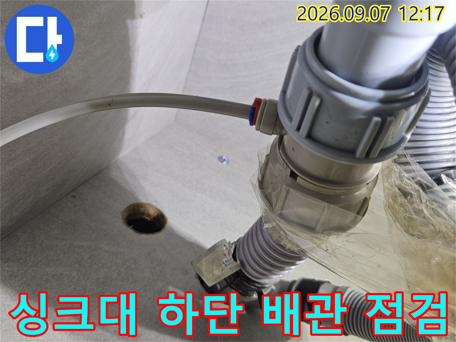싱크대 아래쪽 훼손된 배관과 정수기 호스 연결 상태