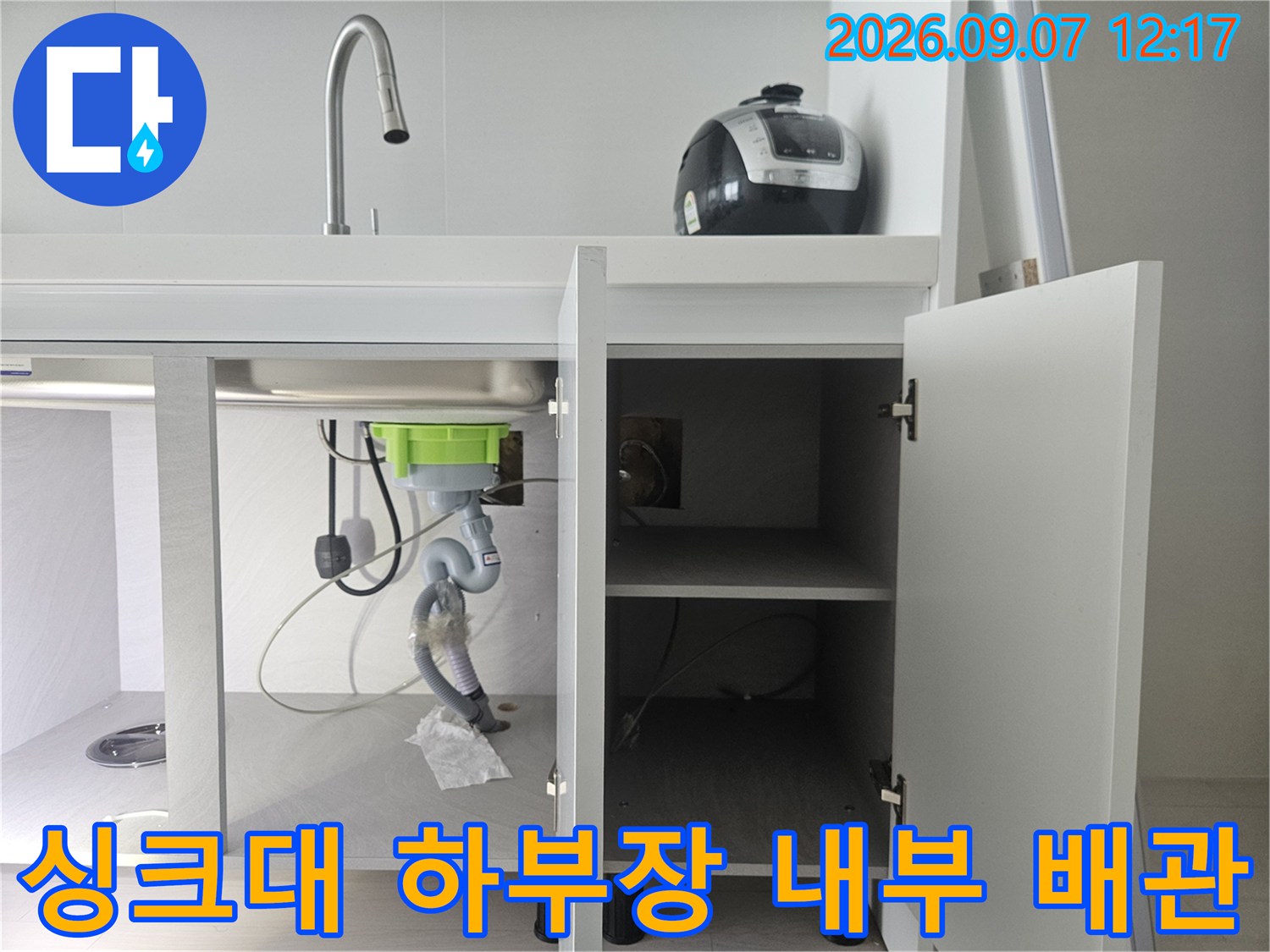 싱크대 하부장 안쪽의 훼손된 호스 및 배관 연결 상태
