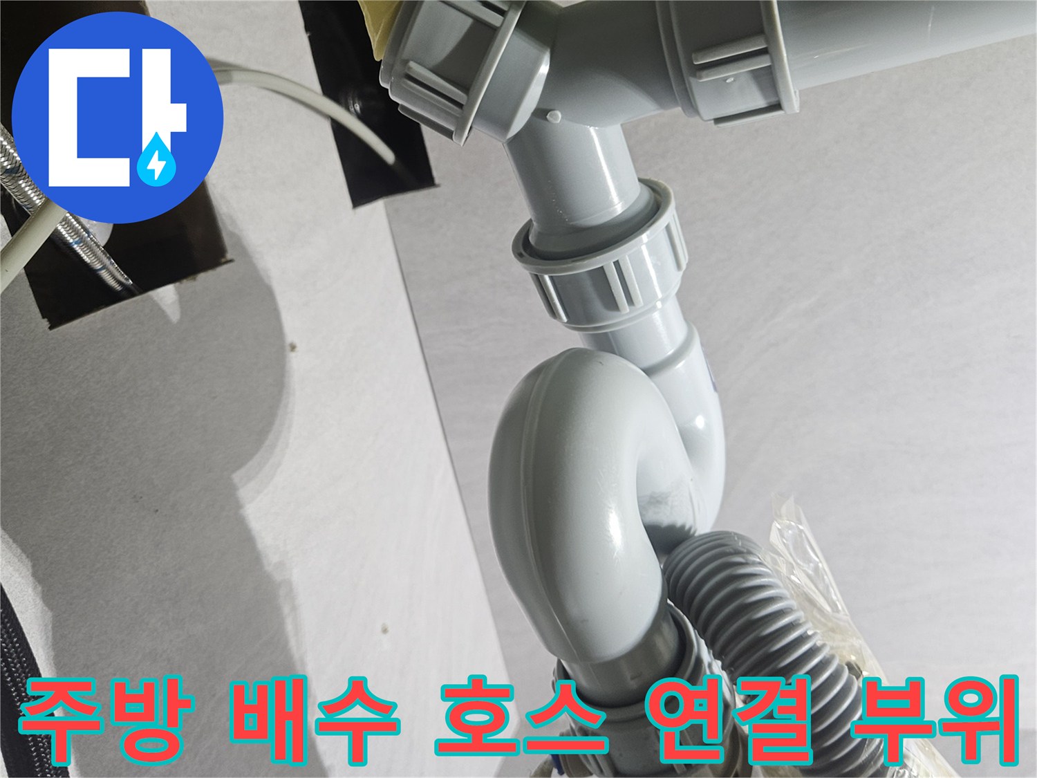 훼손된 정수기 호스와 싱크대 하수관이 연결된 현장 사진입니다.