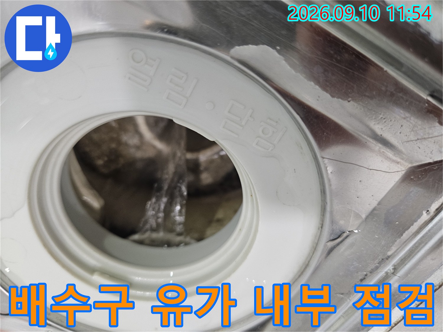 화장실 배수구 내부의 부속과 배관 입구를 촬영한 사진입니다