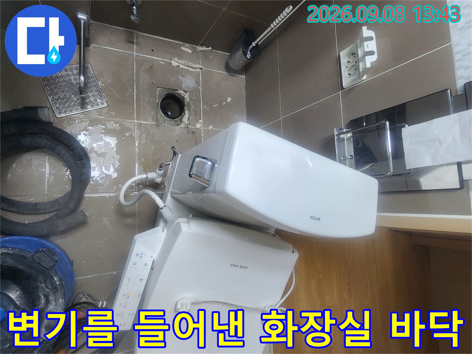 변기 탈거 후 드러난 배수구와 작업 도구가 놓인 현장 모습