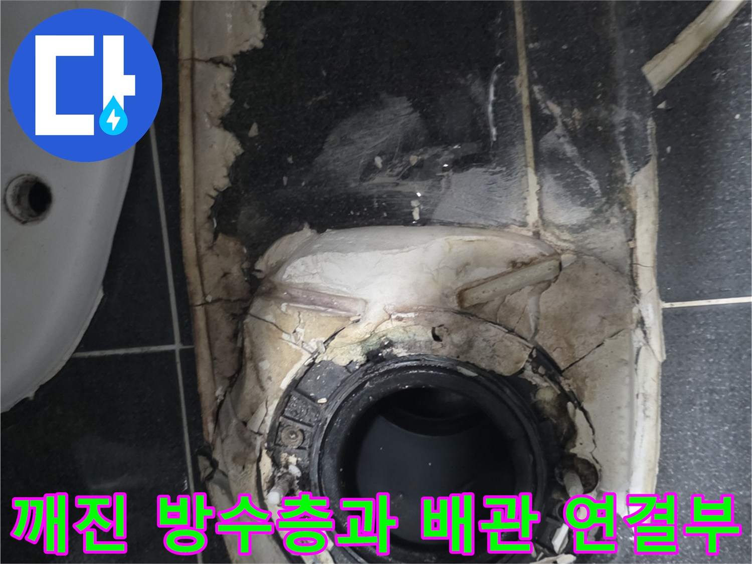 배수구 주변의 부서진 마감재와 노출된 배관
