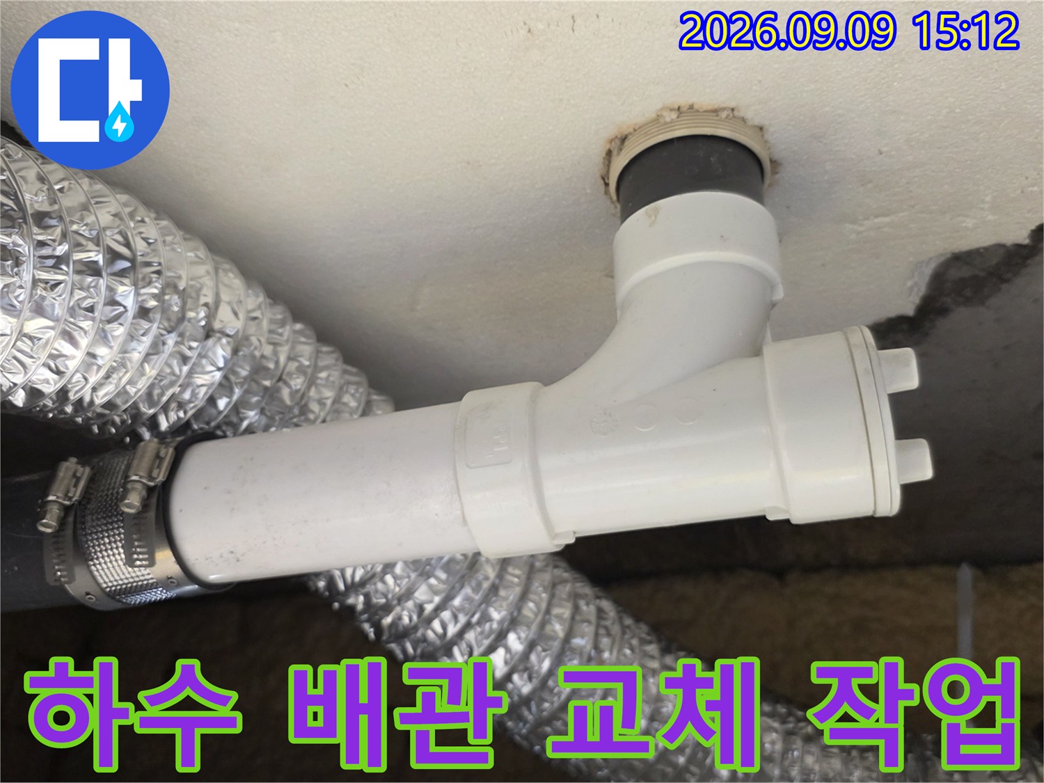 흰색 엘보 배관과 은색 자재가 연결된 천장 내부 배관 구조