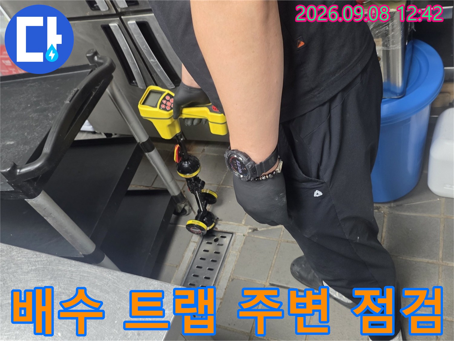 장비를 사용하여 배수 트랩과 트렌치 접합부를 면밀히 관찰하는 장면