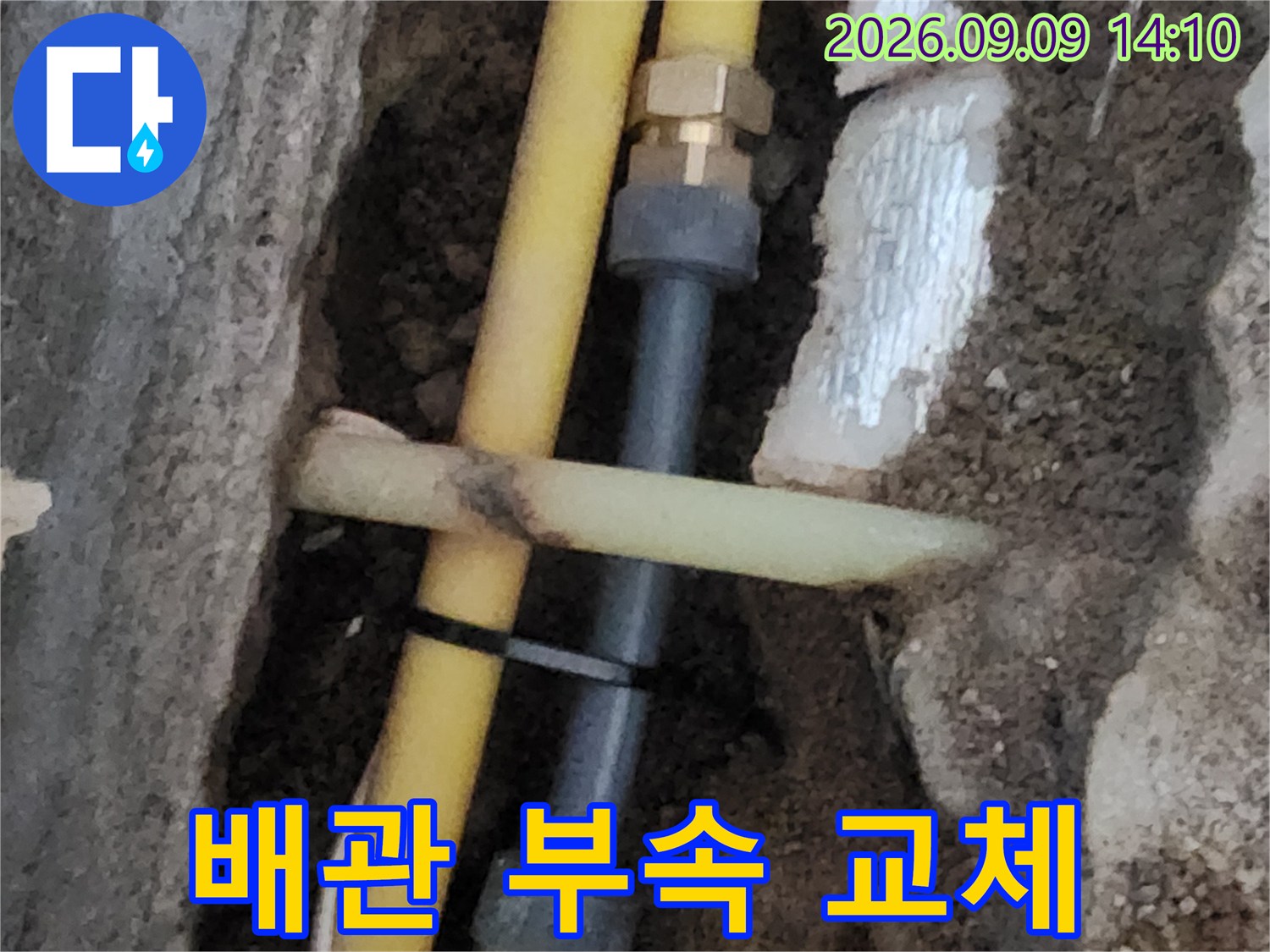 누수가 확인된 노란색 배관에 새 연결 부속을 체결한 수선 완료 모습입니다.