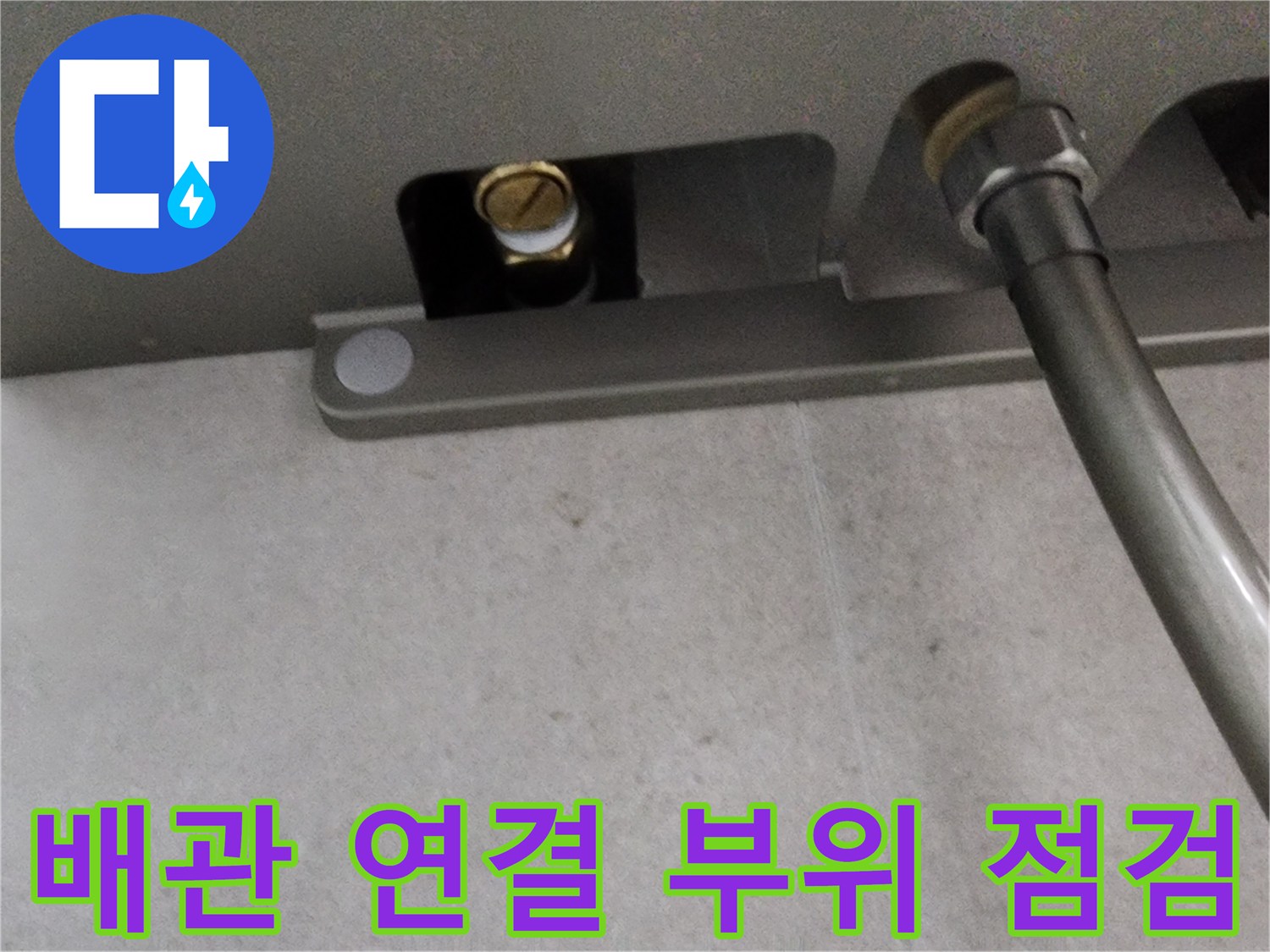 샤워기 수전 뒤쪽의 금속 커플링과 연결된 배관 장비 모습