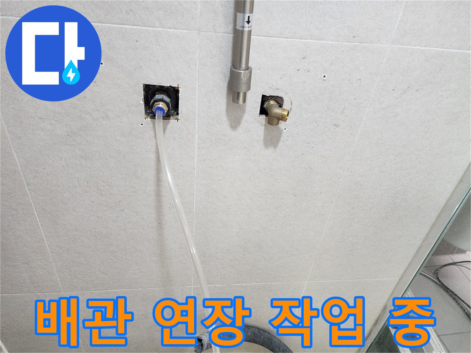 욕실 타일 벽면에 노출된-수도 배관과 연결 부위 모습