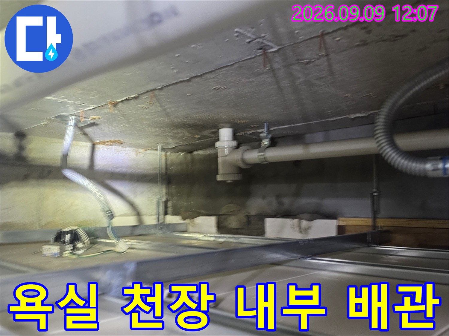 천장 구조물 사이로 보이는 하수 배관과 주변 부속품들