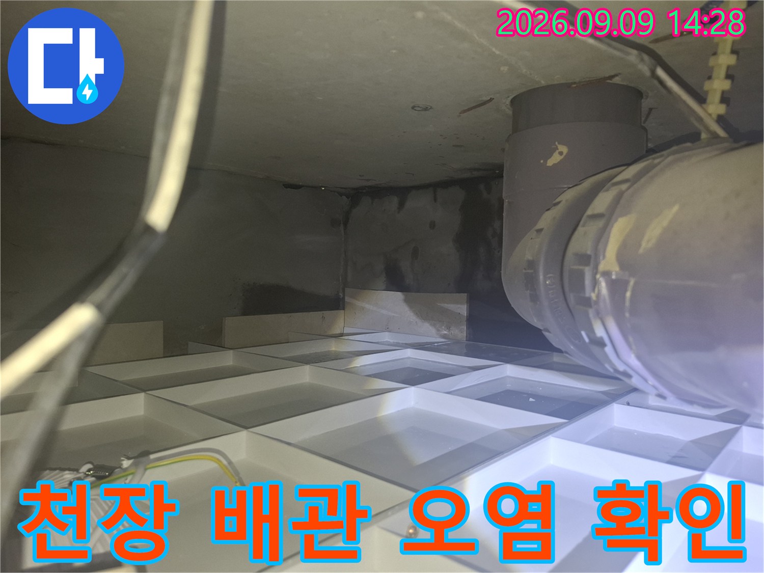 천장 내부의 굵은 배관과 주변 습기 및 오염된 벽면 모습
