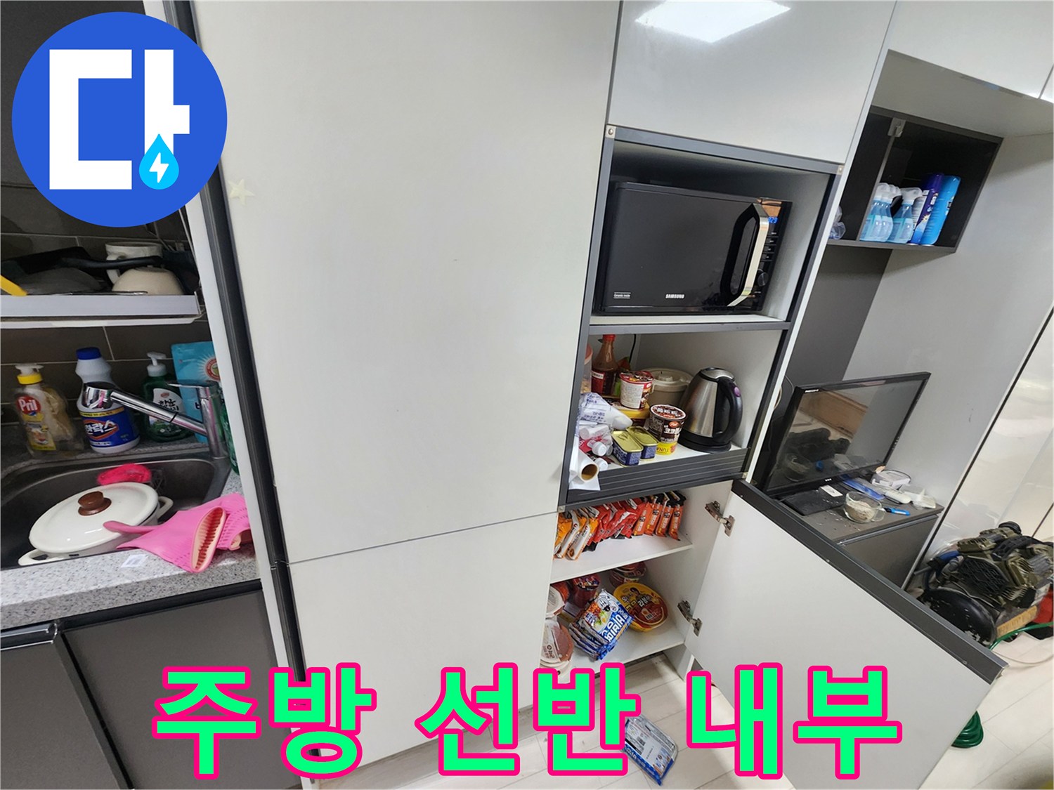 주방 수납장 내 전자레인지와 각종 식재료