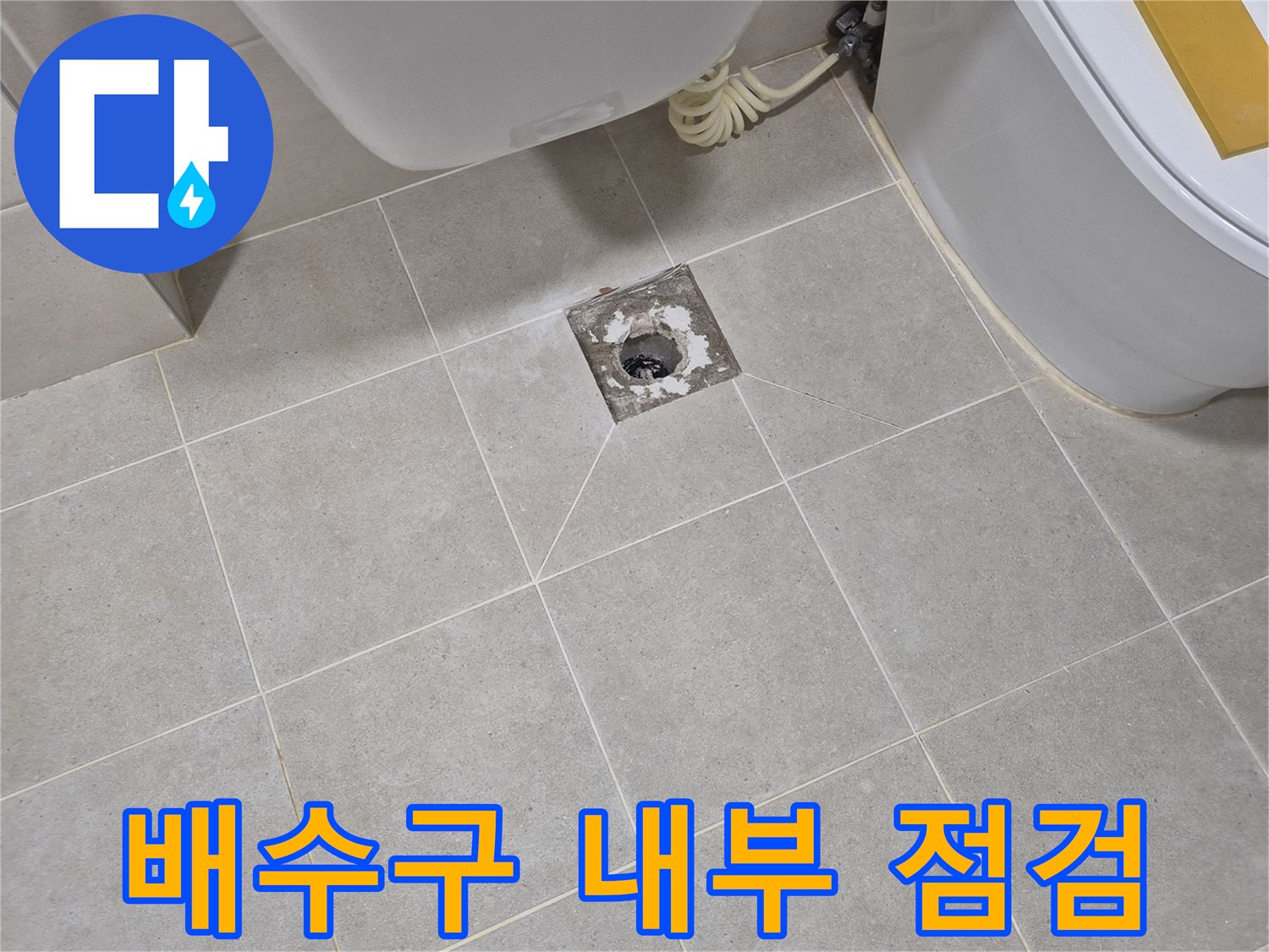 화장실 타일 바닥에 위치한 배수관 입구와 주변 마감재 상태를 촬영했습니다.