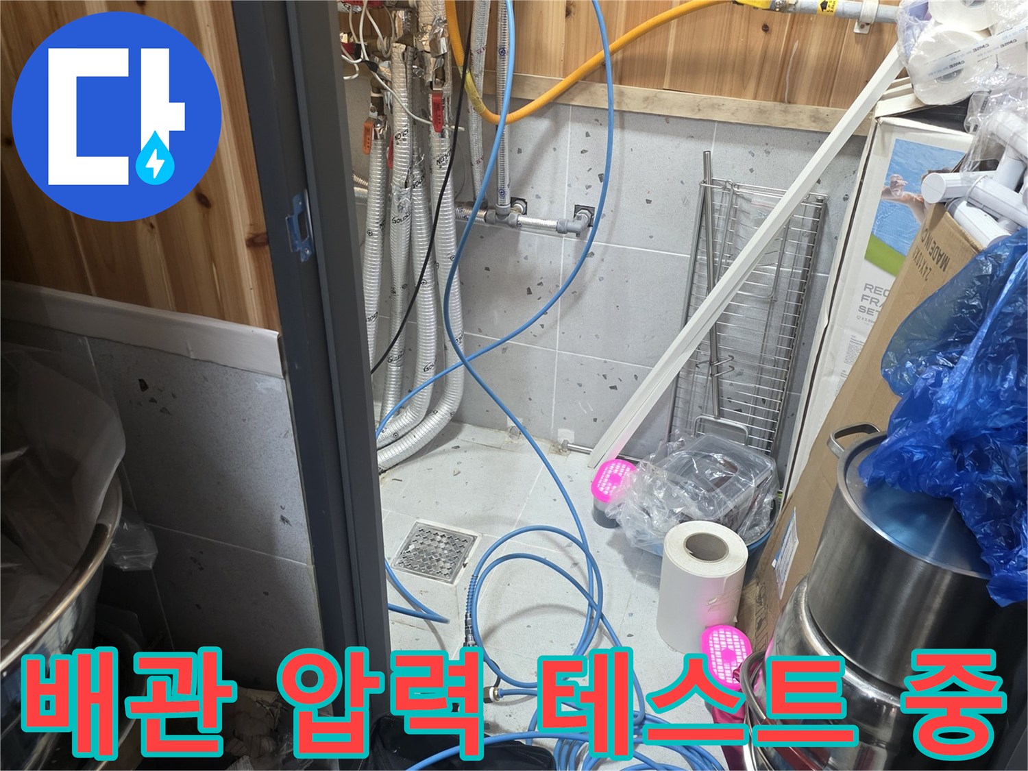 가스 탐지 장비와 파란색 호스가 연결된 배관 점검 모습