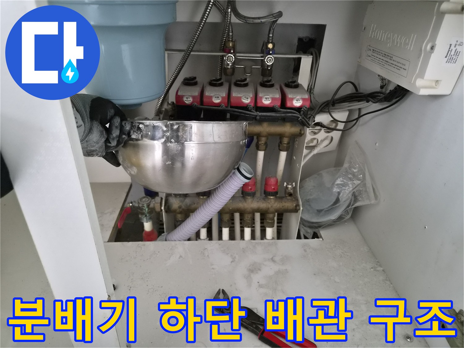 보일러 분배기 아래쪽의-복잡한 배관 연결 부위를 촬영한 사진입니다.