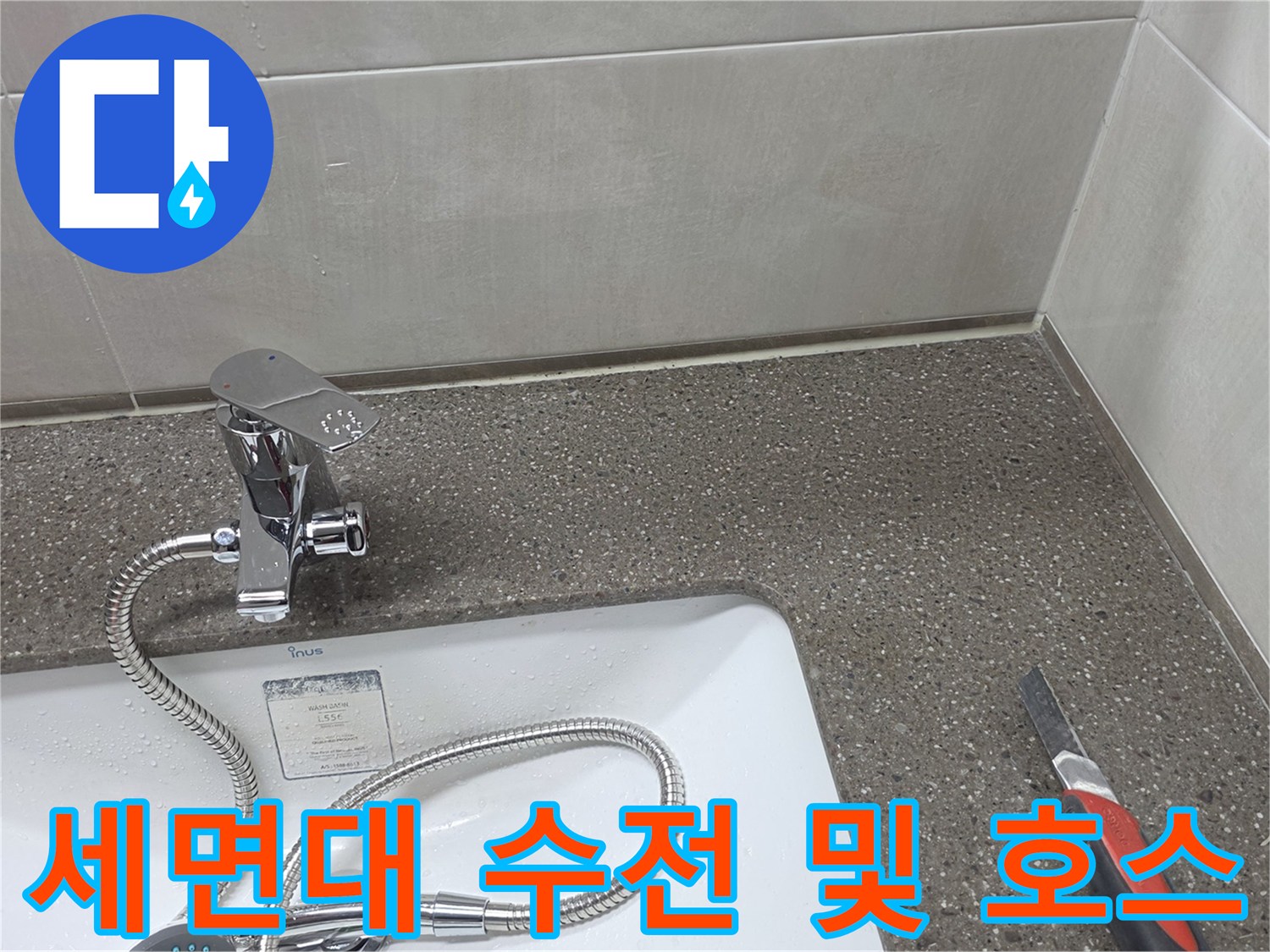세면대 하부의 수전과 연결된 은색 급수 호스