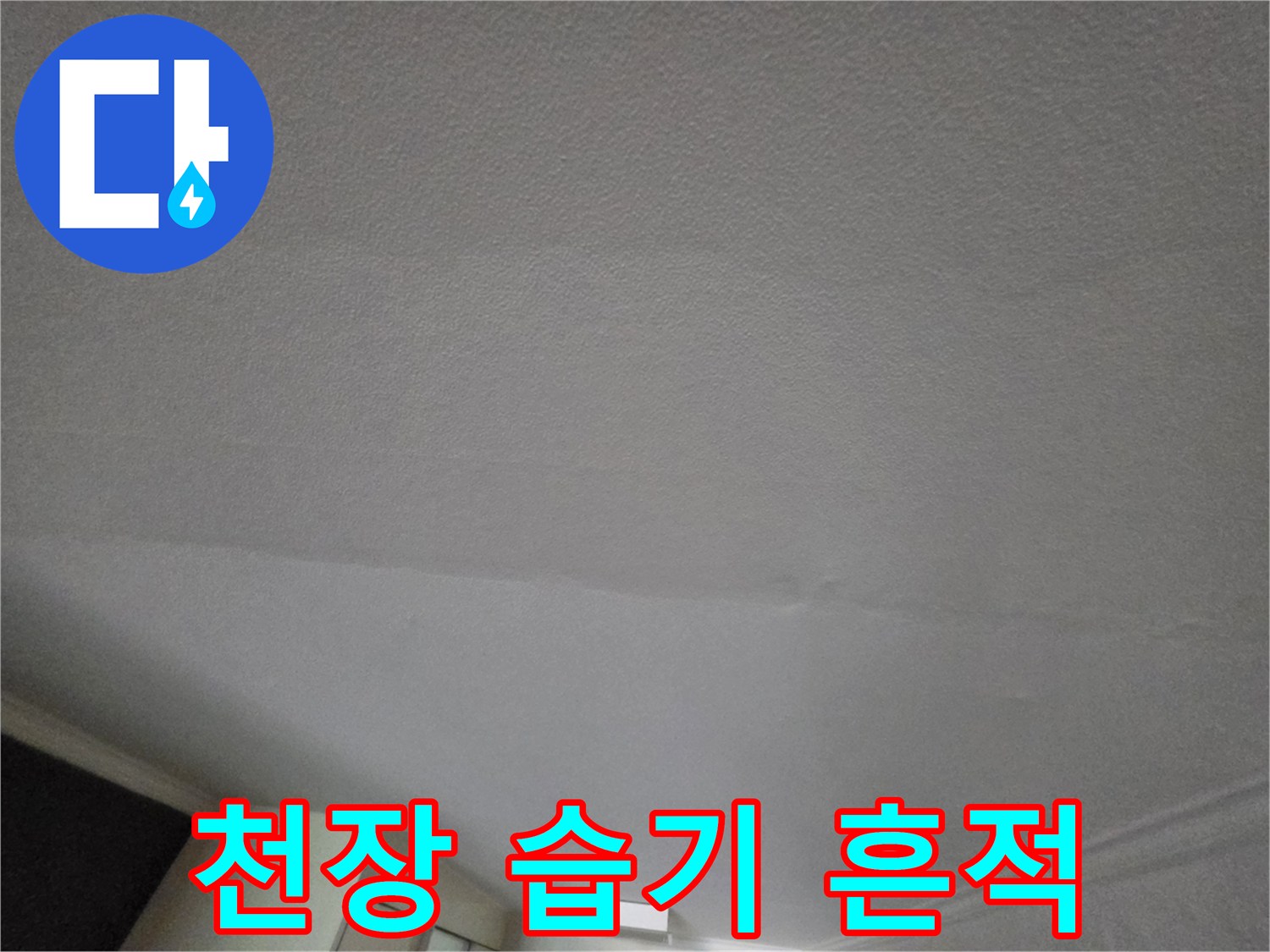 천장 벽지에 발생한 수분 침투 및 변색 부위를 촬영한 사진입니다.