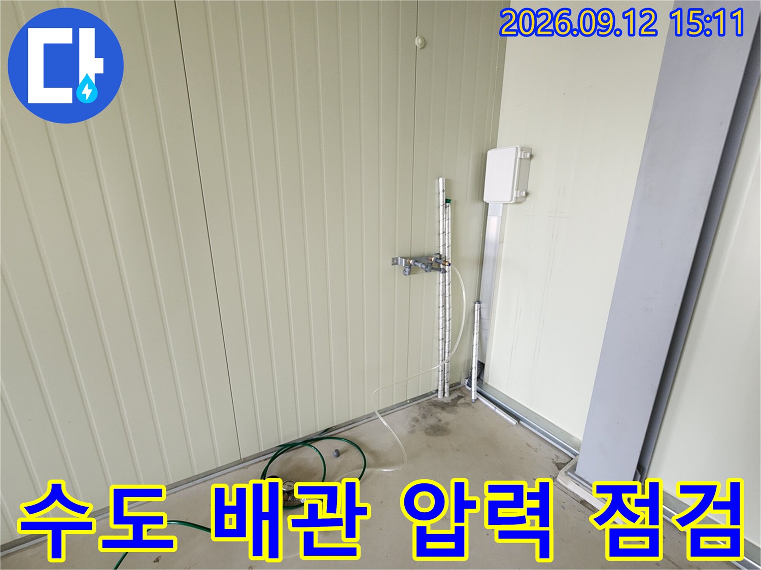 수직으로 세워진 금속 배관과 연결된 압력 측정 장치 이미지