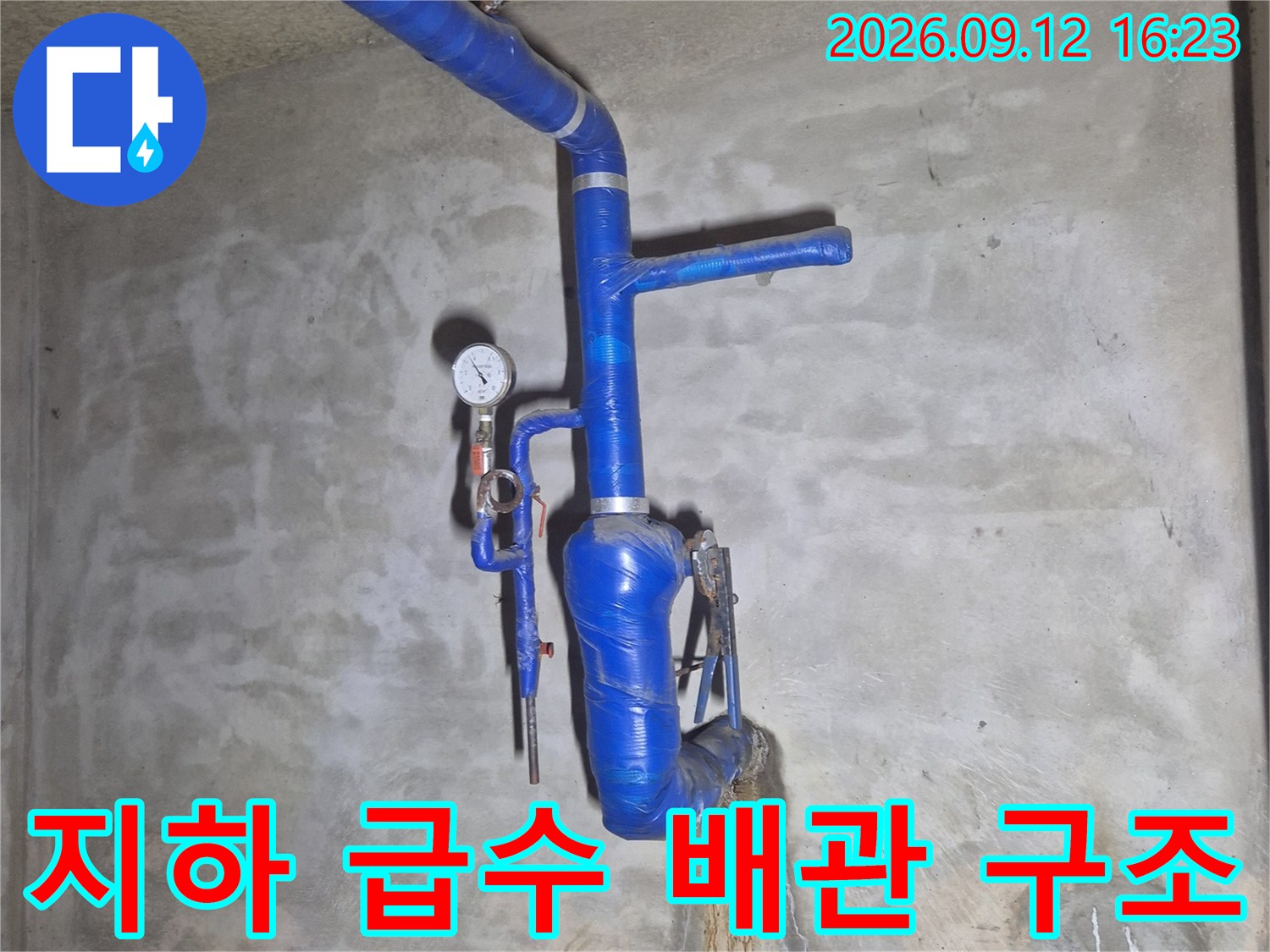 파란색 보온재가 설치된-아파트 지하의 급수 관로와 계량기