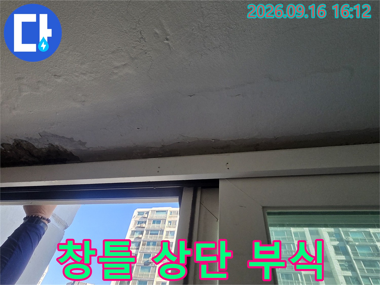 아파트 창틀 위쪽 천장 콘크리트가 젖어 있고 페인트가 떨어져 나간 상태