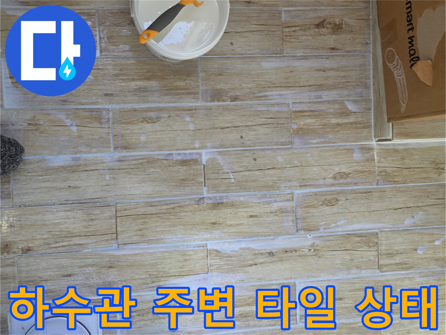 하수관 근처의 물기가 남은 타일 바닥과 배관 연결부 점검 상황