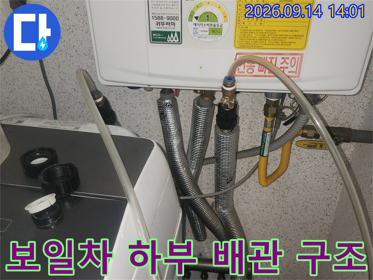 보일러 본체와 연결된 은색 주름관과 노란색 호스 상세