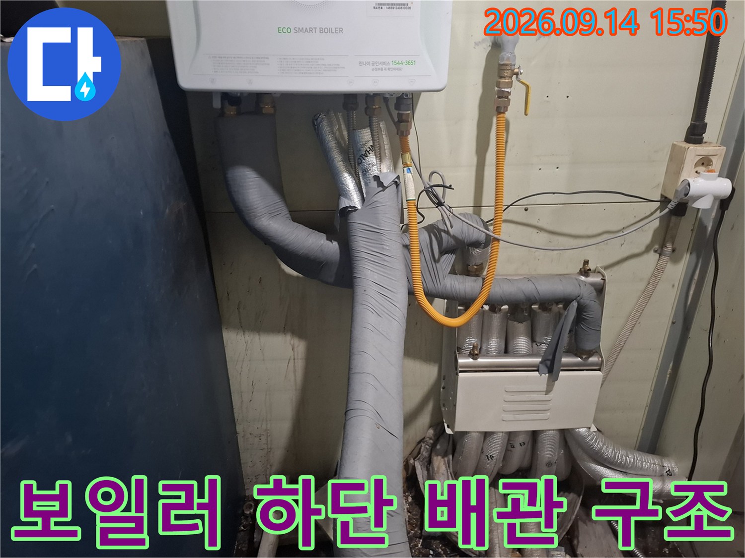 보일러 아래쪽의 보온재로 감싸진 배관들과 밸브 연결 부위 사진입니다.