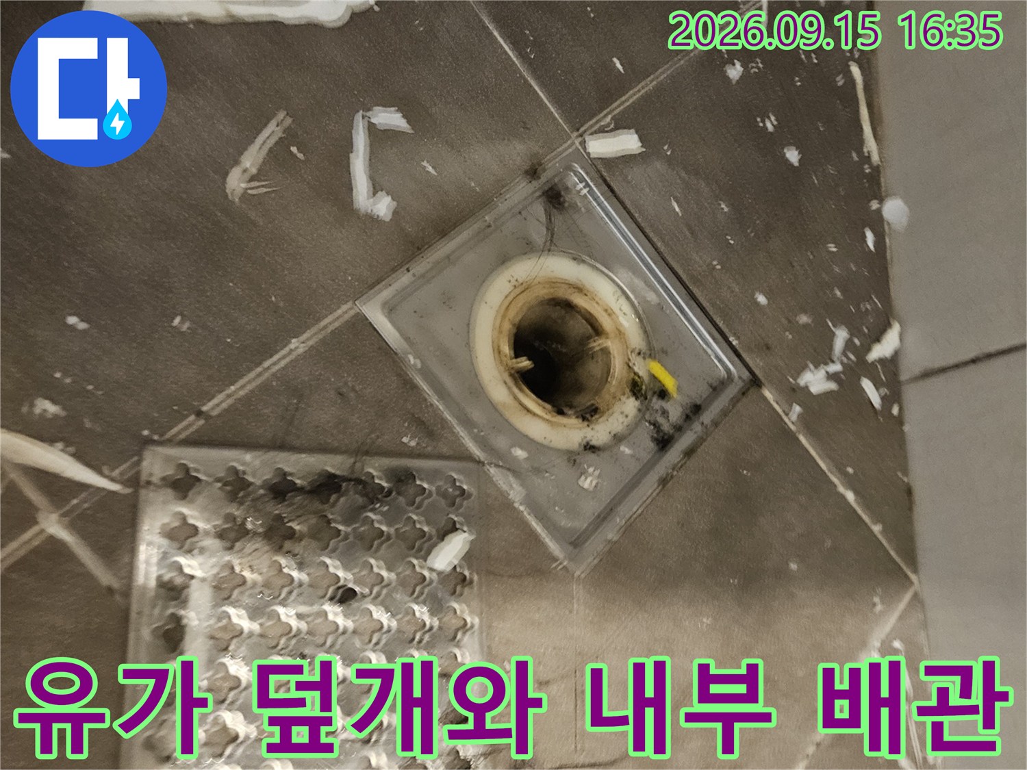 옆으로 치워진-유가 덮개와 노출된 배수구 내부 구조