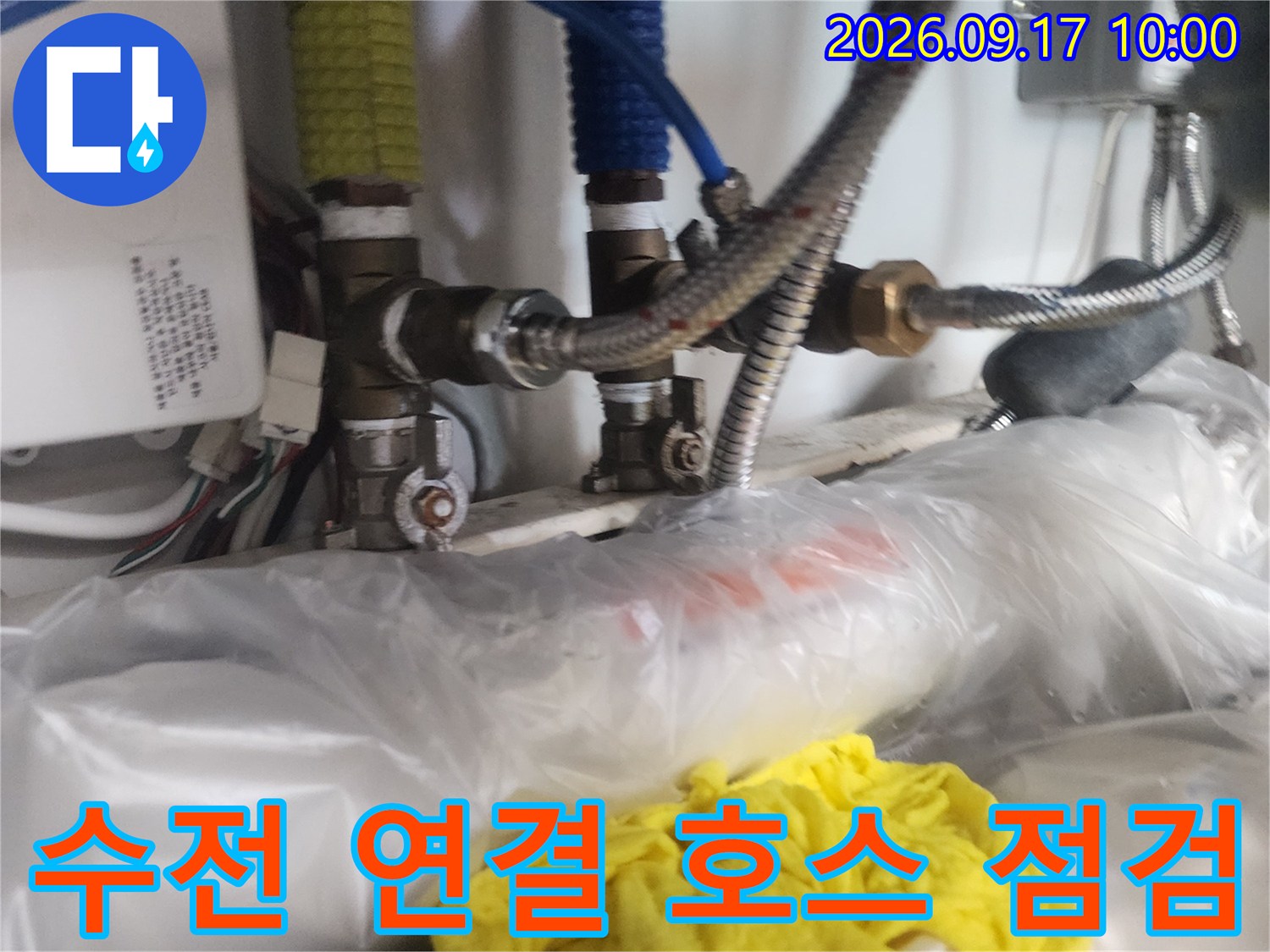 금속 재질의 유연한 배관과 수전 연결부를 정밀하게 확인하는 작업 장면입니다.