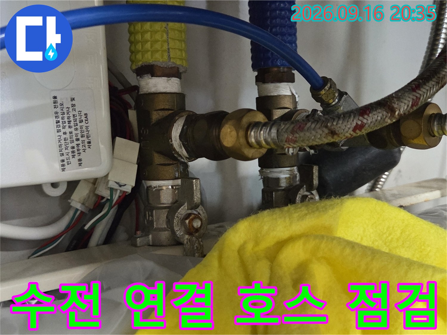 파란색과 은색의 수전 연결 호스가 복잡하게 얽힌 배관 모습입니다.