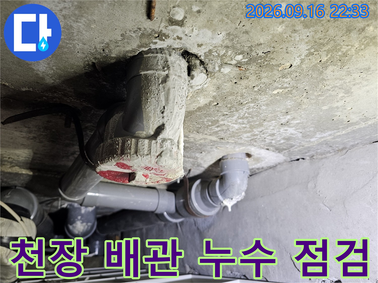 천장 슬래브를 관통하는 하수 배관과 연결 부위의 근접 촬영입니다.
