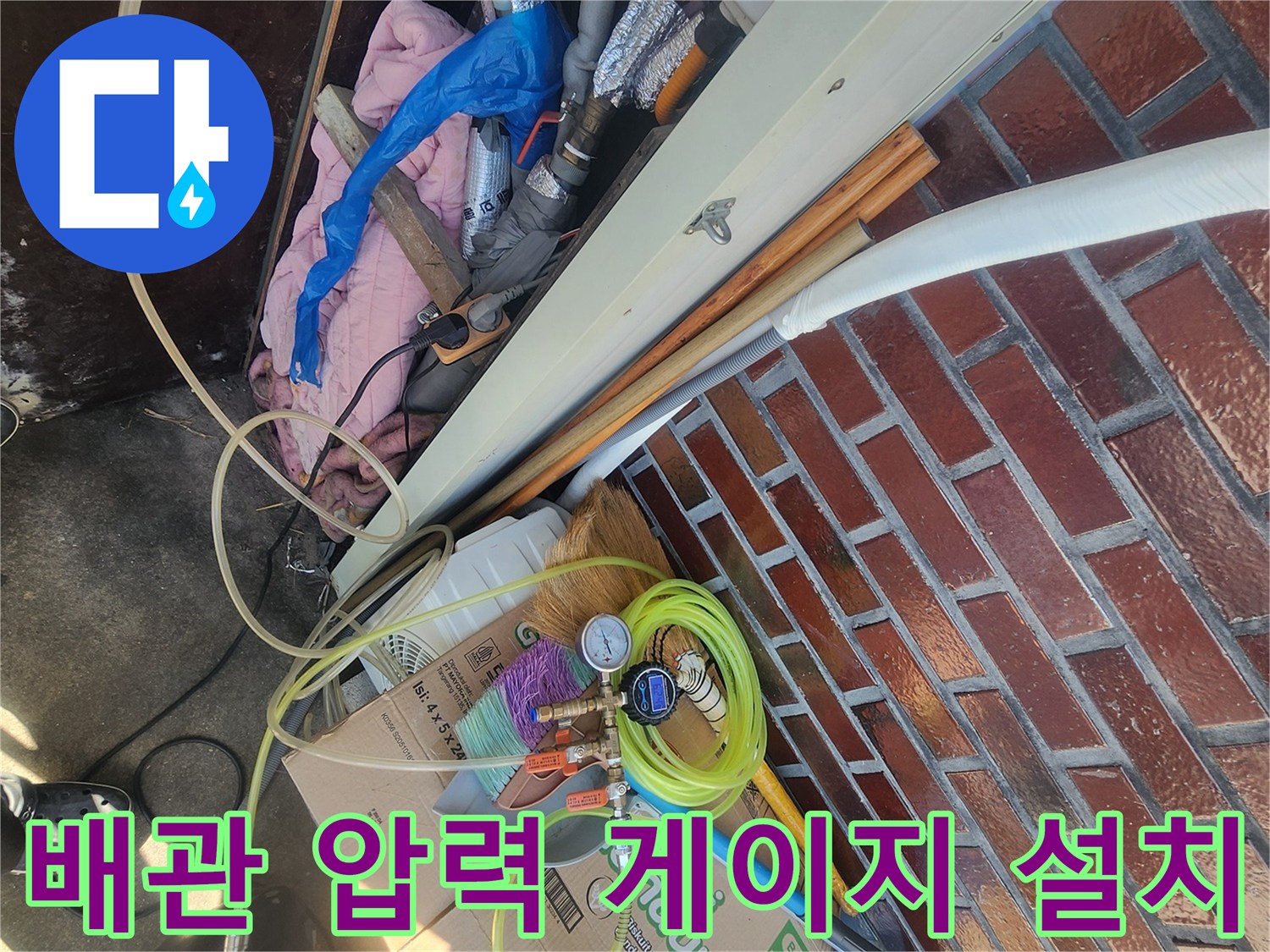 벽돌-외벽-옆-수도-계량기에-연결된-공압-테스트-장비