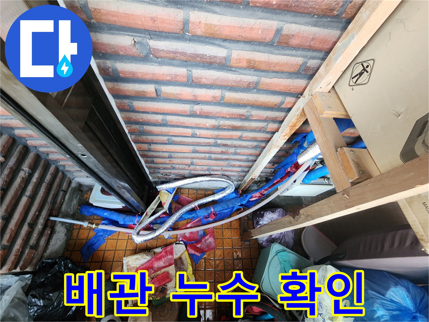 벽돌 벽체와-파란색 보온재가 벗겨진 배관의 모습