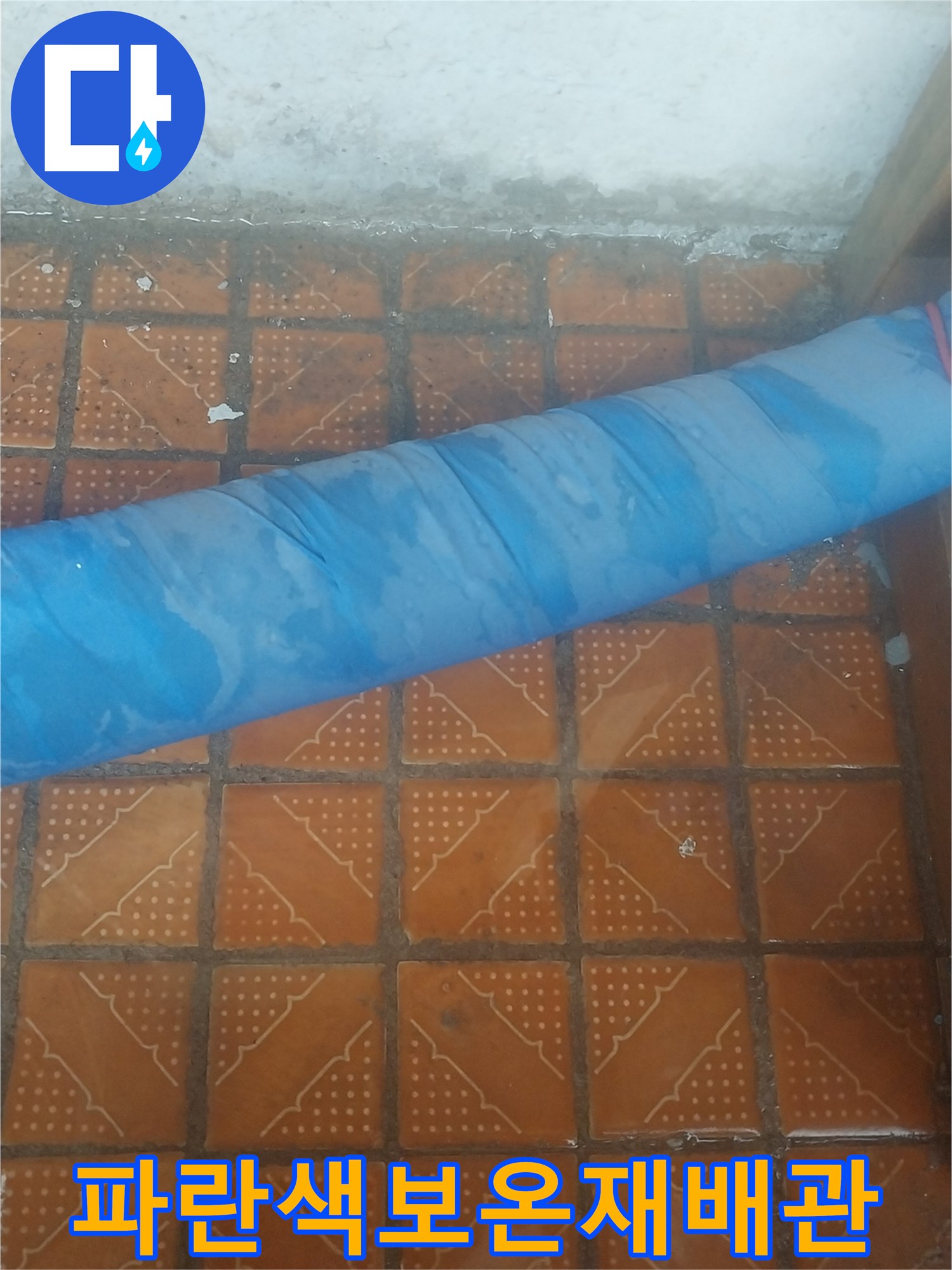 파란색 보온재와 테이프로 감겨있는 배수 배관의 모습입니다.